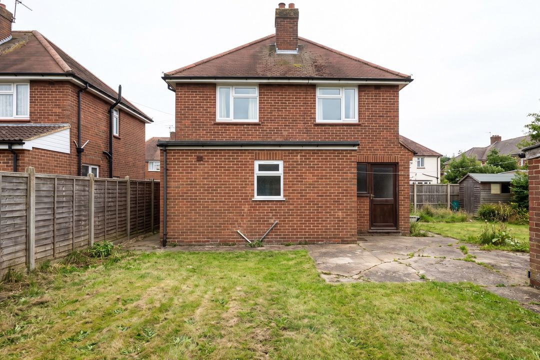 Before: the back of a red-brick semi with a small window, a back door and a cracked patio.